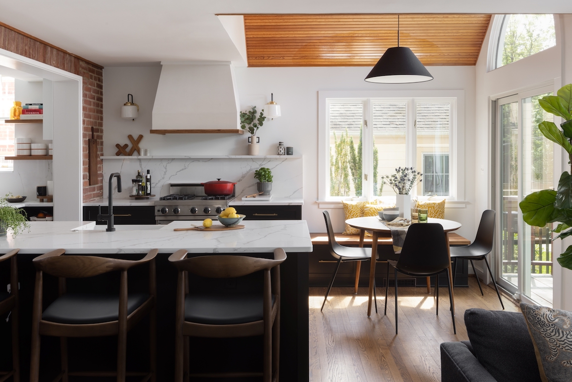 Open concept kitchen and dining room space with a black island and white countertop. Luxury Kitchen Renovation